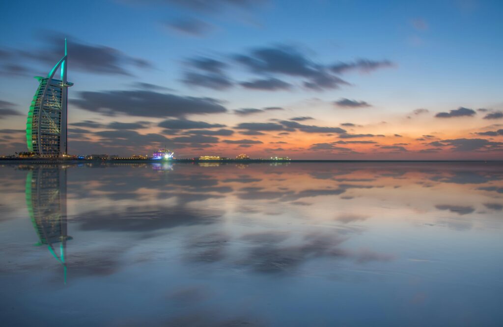 Scenic view of Burj Al Arab with stunning dusk reflections in Dubai's calm sea.