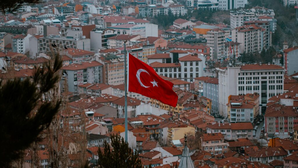 Aerial view of Afyonkarahisar city with the Turkish flag prominently displayed.
