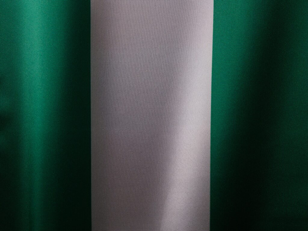 Detailed view of the Nigerian flag's textile texture, showing green and white stripes.
