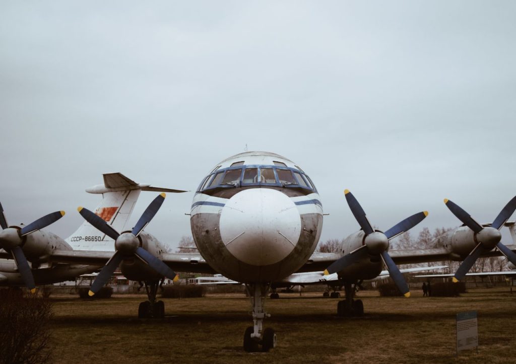 Front view of a vintage Soviet-era propeller airplane outdoors in an open-air museum setting.