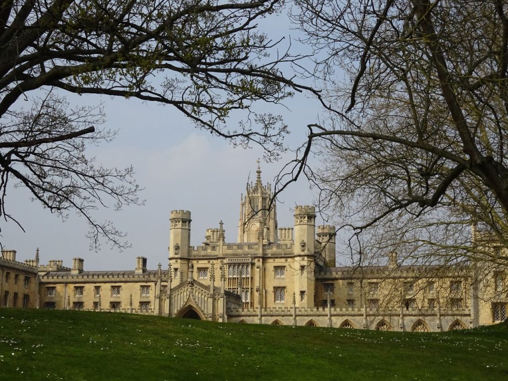 Majestic architecture of a college building in Cambridge, framed by trees.